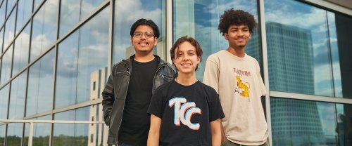 Three young male TCC students stand ouside of the Thomas K. McKeon Center for Creativity